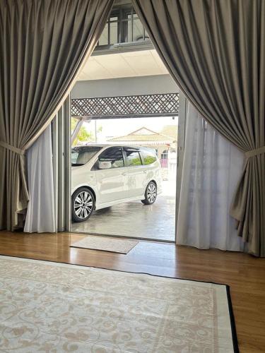 a white car is parked outside of a window at Alora Homestay in Alor Setar