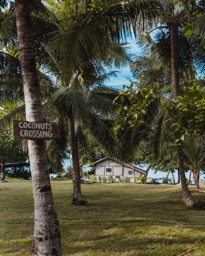 a sign on a palm tree that reads crocodiles crossing at Matevulu Lodge in Luganville