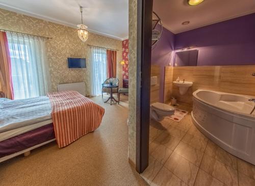 a bathroom with a bed and a tub and a sink at Arkadia Gościniec-klima,parking,ogród in Opole