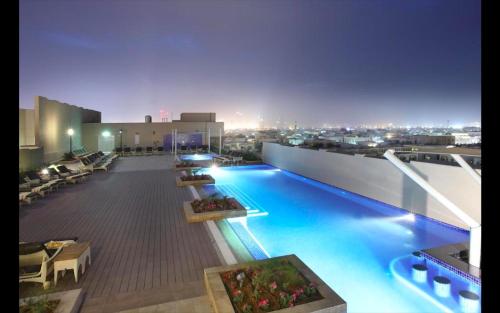 a large swimming pool on top of a building at Metropolitain Dubai Hotel - Junior Suite - UAE in Dubai