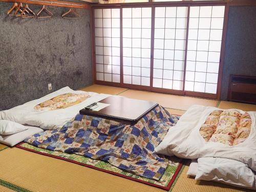 香美町的住宿－Hachikita U Base，一间设有两张床和一张桌子的客房
