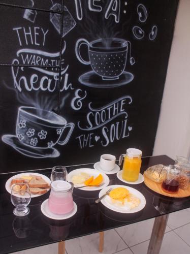 a table with plates of breakfast foods and a chalkboard at Pousada Loft vista da serra in Serra de São Bento
