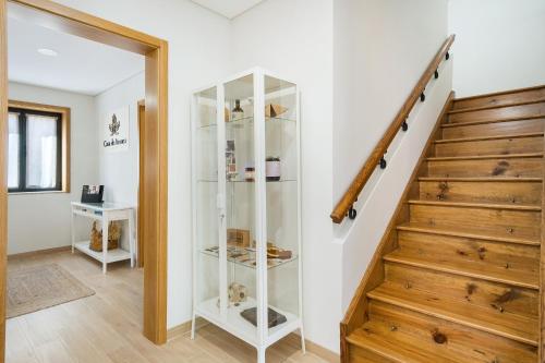 a glass cabinet in a hallway next to a staircase at Casa de Arouca - Arouca Suítes in Arouca