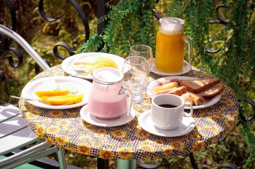 a table with a breakfast of eggs and toast and orange juice at Pousada Loft vista da serra in Serra de São Bento