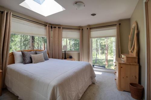 ein Schlafzimmer mit einem großen Bett und großen Fenstern in der Unterkunft Jacobs Ladder - Black Butte Ranch in Sisters