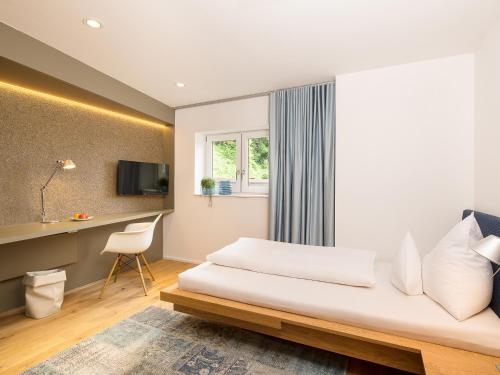 a hotel room with a bed and a desk at Gasthof Schopper in Breitenbach am Inn