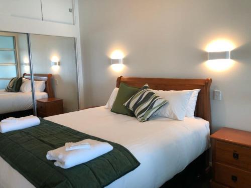 1 dormitorio con 1 cama con 2 toallas en Spacious Executive Apartmt,great Views! Location en Auckland
