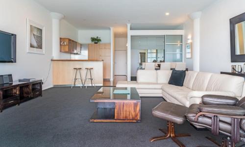 sala de estar con sofá blanco y mesa en Spacious Executive Apartmt,great Views! Location en Auckland
