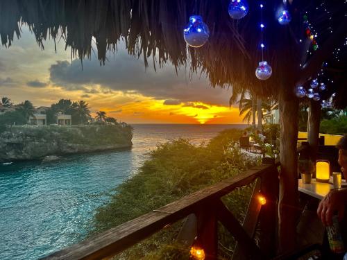 a view of a sunset from a restaurant with the ocean at Marazul Dive Resort-Panoramic Ocean View Town Home in Westpunt