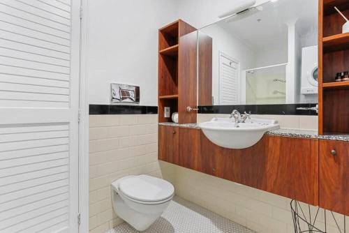 a bathroom with a toilet and a sink at Funky One Bedroom Apartment on Princes Wharf in Auckland