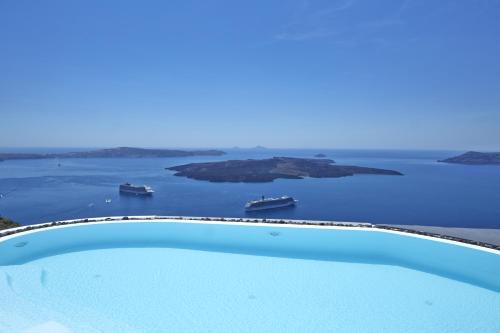 a swimming pool with a view of the ocean at Alta Vista Suites in Firostefani