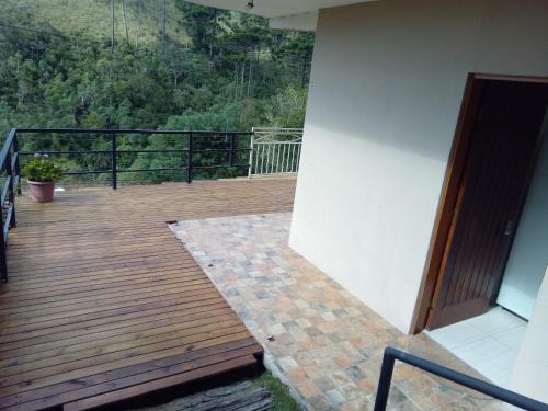une terrasse en bois avec une porte sur un balcon. dans l'établissement Casa dos Neves, à Campos do Jordão