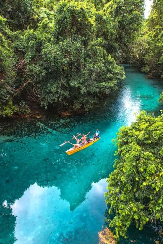 a group of people in a boat in a river at Matevulu Lodge in Luganville