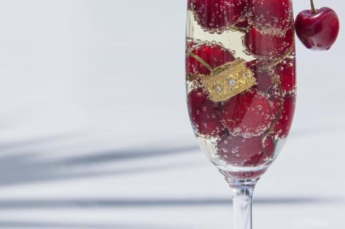 a wine glass filled with cherries and a ring at Alta Vista Suites in Firostefani