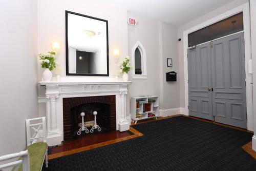 Furnished Newbury Street Studio, #6 في بوسطن: غرفة معيشة مع موقد ومرآة