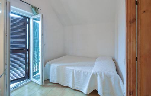 a white bedroom with a bed and a window at 2 Bedroom Lovely Home In Serrone in Serrone