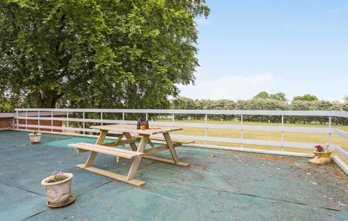 a wooden picnic table sitting next to a fence at Lovely Apartment In Erslev With Wifi in Erslev