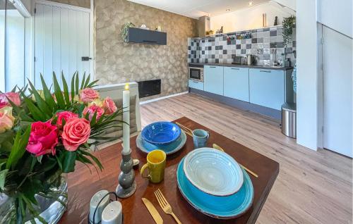a kitchen and a table with plates and flowers on it at Cozy Home In Noordscheschut With Wifi in Noordscheschut