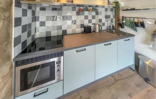 a kitchen with a stove and a sink at Cozy Home In Noordscheschut With Wifi in Noordscheschut