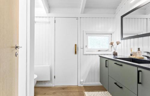 een witte badkamer met een wastafel en een toilet bij Gorgeous Home In Strandby With Kitchen in Strandby