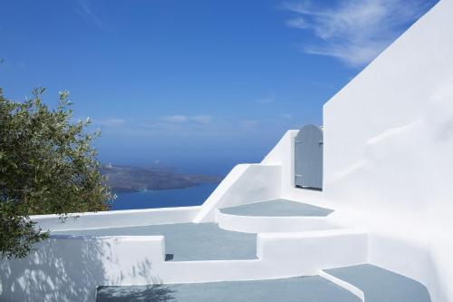 a staircase leading up to a white house with a blue sky at Alta Vista Suites in Firostefani