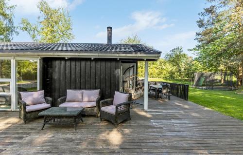 a wooden deck with chairs and a fireplace at 4 Bedroom Beautiful Home In Gilleleje in Gilleleje