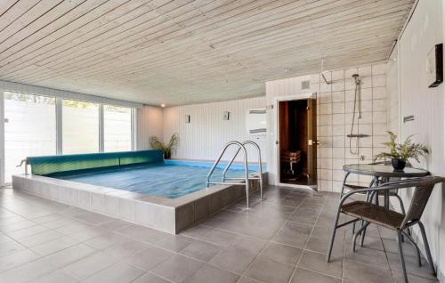 Hvalpsundにある3 Bedroom Amazing Home In Farsのテーブル付きの客室内の大きなスイミングプール