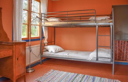 2 Etagenbetten in einem Zimmer mit orangefarbener Wand in der Unterkunft Gorgeous Home In Jmj With Kitchen in JÃ¤mjÃ¶