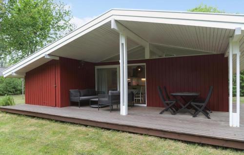 a covered deck with chairs and a table at 3 Bedroom Lovely Home In Melby in Melby