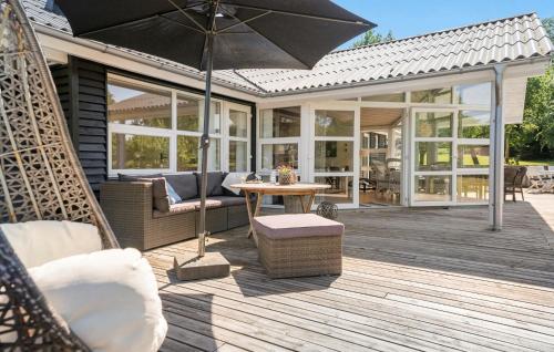 an outdoor patio with a table and an umbrella at Pet Friendly Home In Farsø With Wifi in Farsø