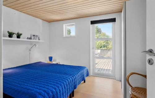 a bedroom with a blue bed and a window at Pet Friendly Home In Farsø With Wifi in Farsø