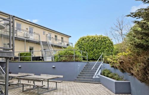 a patio with a table and stairs in front of a building at Amazing Apartment In Allinge With Wifi in Allinge