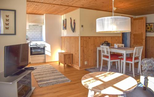 a kitchen and living room with a table and a tv at Amazing Home In Markaryd With Lake View in Markaryd