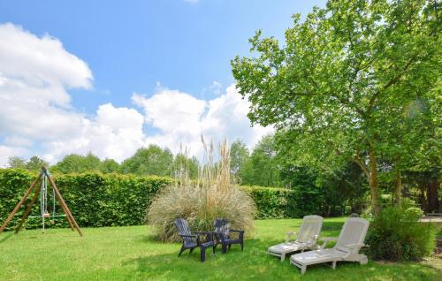 a group of chairs and a swing set in a yard at Cozy Home In Saint-Pierre-En-Auge in Sainte-Marguerite-de-Viette