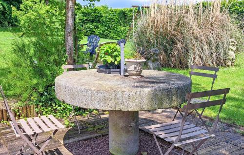 a stone table with two chairs and a plant on it at Cozy Home In Saint-Pierre-En-Auge in Sainte-Marguerite-de-Viette