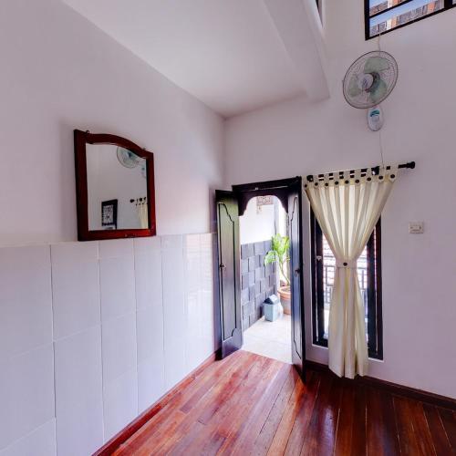 a room with a door with a curtain and a mirror at Tirta Yoga Inn in Padangbai