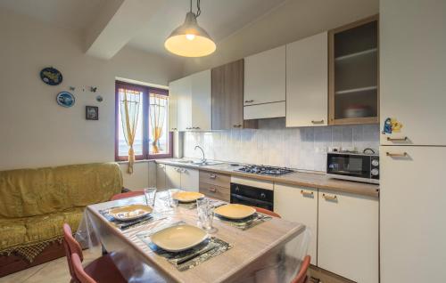 a kitchen with a table with plates on it at 2 Bedroom Awesome Apartment In Messina in Briga Marina