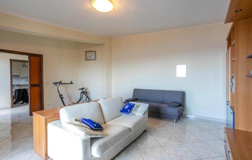 a living room with a white couch and a chair at 2 Bedroom Awesome Apartment In Messina in Briga Marina