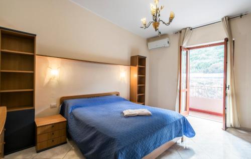 a bedroom with a blue bed and a window at Cozy Apartment In Messina With House Sea View in Briga Marina