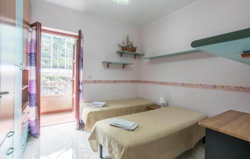 two beds in a room with a window at 2 Bedroom Awesome Apartment In Messina in Briga Marina
