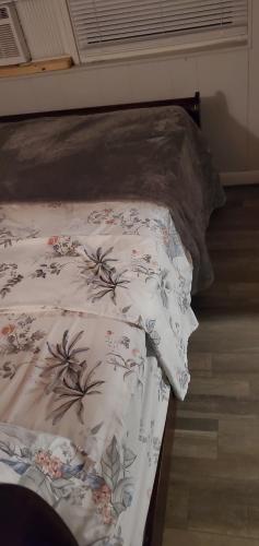 a bed with a comforter with flowers on it at Private Studios Orlando in Orlando