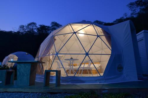 una grande tenda a cupola con un tavolo all'interno di notte di NiNo San Glamping - Pak Chong a Pak Chong