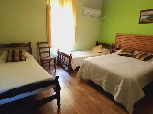 - une chambre avec 2 lits et une fenêtre dans l'établissement Solar de Campo, à Villa Elisa