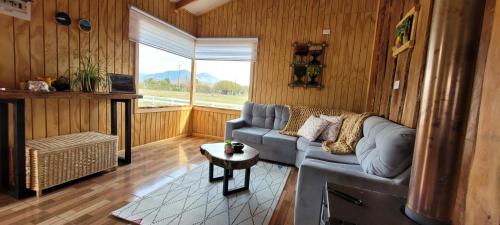 a living room with a couch and a table at Cabañas Antü Küyen Melipeuco in Melipeuco