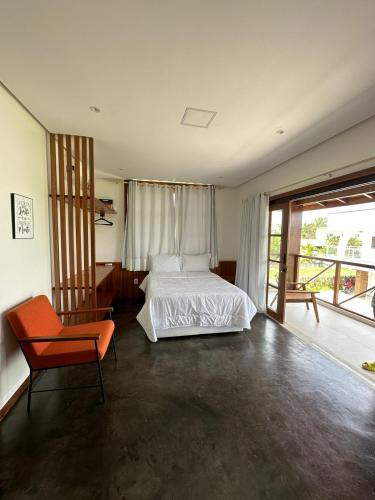a bedroom with a white bed and a chair at Casa Aconchego - Barreirinhas in Barreirinhas