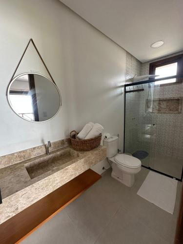 a bathroom with a sink and a toilet and a mirror at Casa Aconchego - Barreirinhas in Barreirinhas