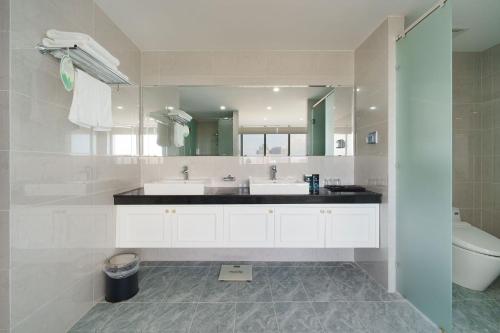 ein Badezimmer mit zwei Waschbecken und einem großen Spiegel in der Unterkunft Victory Hotel Vung Tau in Vũng Tàu
