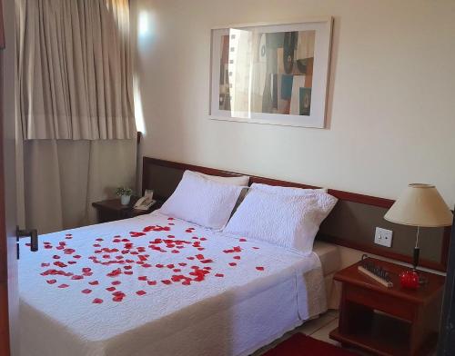 a bedroom with a bed with red roses on it at Bassano Vaccarini in Ribeirão Preto