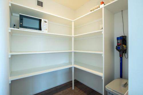 a walk in closet with shelves and a microwave at Ebisu in Kutchan
