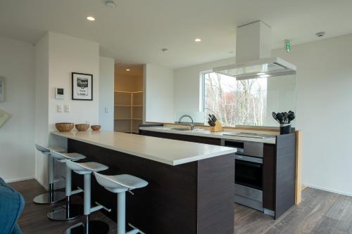 a kitchen with a large island with bar stools at Ebisu in Kutchan